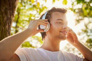 Qual è il significato della canzone "Come nei giorni migliori" 28 giovane che ascolta musica sorridendo allaperto