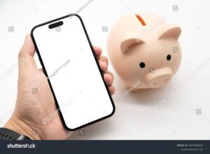 Quali Vantaggi Offre Uno Smart Bank Conto Deposito 9 mani che utilizzano smartphone vicino a salvadanaio