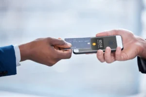 Come funziona Tap to Cash in Italia per pagamenti contactless 28 mano che avvicina smartphone a terminale pagamenti contactless