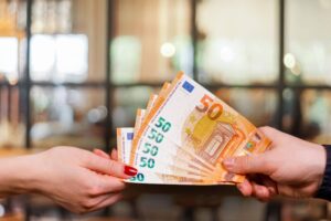 mano che scambia carta con banca in sfondo