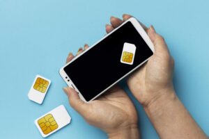 mano che scambia due schede sim smartphone