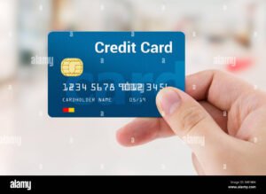 mano che tiene bancomat e carta credito