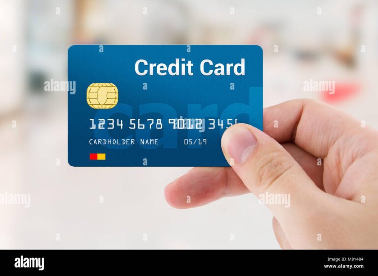 mano che tiene bancomat e carta credito