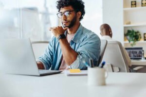 Come Si Può Iniziare A Lavorare Con I Computer E Quali Sono Le Opzioni 14 persona che utilizza un laptop in ambiente di lavoro moderno