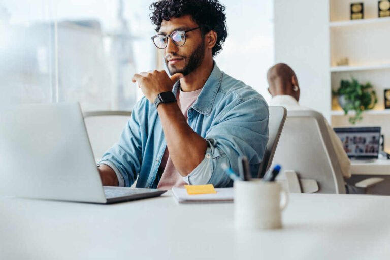 persona che utilizza un laptop in ambiente di lavoro moderno