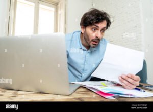 persona preoccupata davanti a computer e documenti finanziari