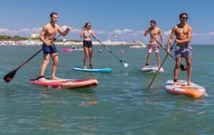persone diverse che praticano stand up paddle