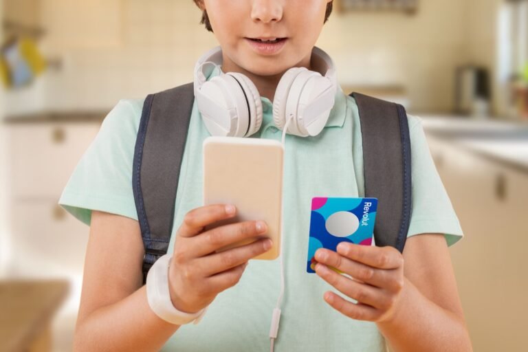 ragazzi felici con smartphone e carta revolut