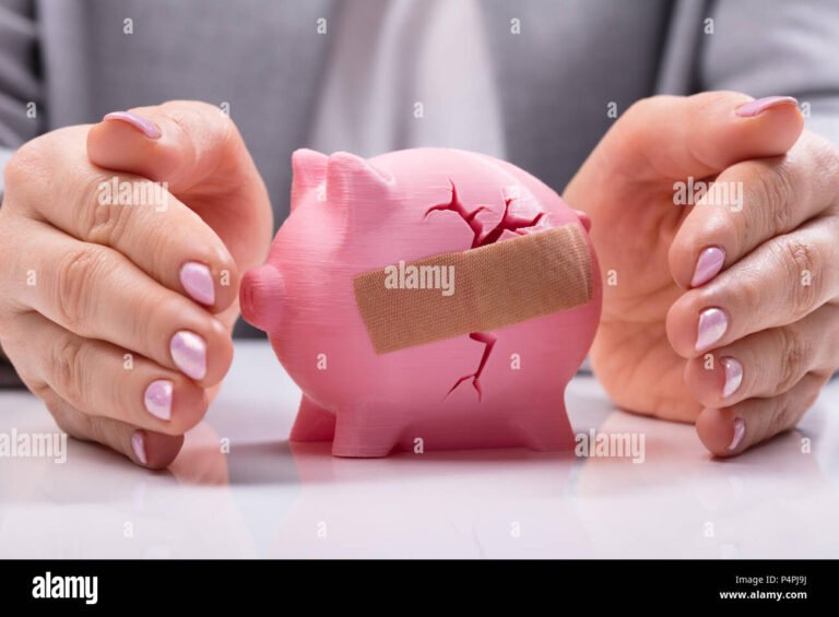 una mano che protegge un salvadanaio rotto